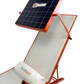 An orange solar-powered outdoor lounge chair with a built-in solar panel on a white background. The chair is shown with a white rolled towel, sunglasses, and a small accessory on the seat.